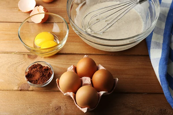 Crema de preparación con huevos en cuenco de vidrio sobre fondo de madera — Foto de Stock