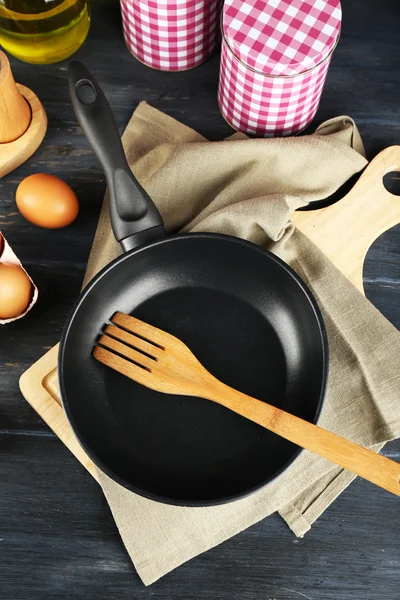 Stilleven met eieren en pan op houten tafel, bovenaanzicht — Stockfoto