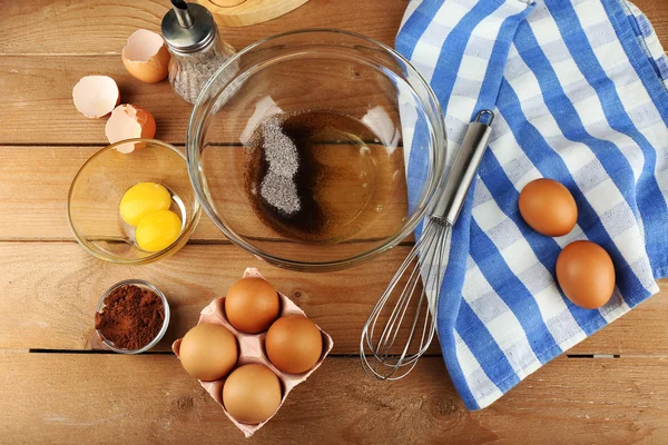 Приготування вершків з яйцями в скляній мисці на дерев'яному фоні — стокове фото