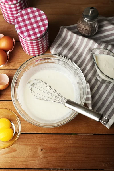 Crema di preparazione con uova in ciotola di vetro su tavolo di legno, vista dall'alto — Foto Stock