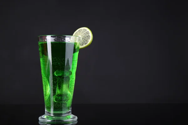 Flaming green cocktail on dark background — Stock Photo, Image