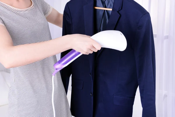 Mujer steaming shirt in room — Foto de Stock