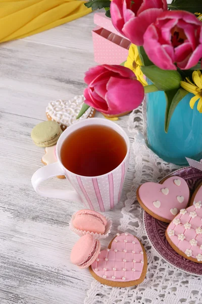 Composition of spring flowers, tea and cookies on table close-up — Stock Photo, Image
