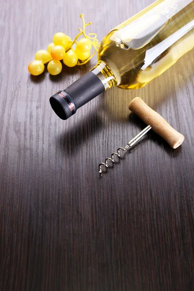 Şişe şarap üzüm ve tirbuşon ahşap arka plan üzerinde — Stok fotoğraf
