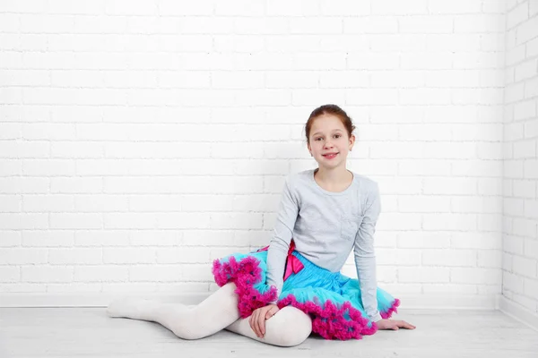 Hermosa niña sobre fondo de pared de ladrillos blancos — Foto de Stock