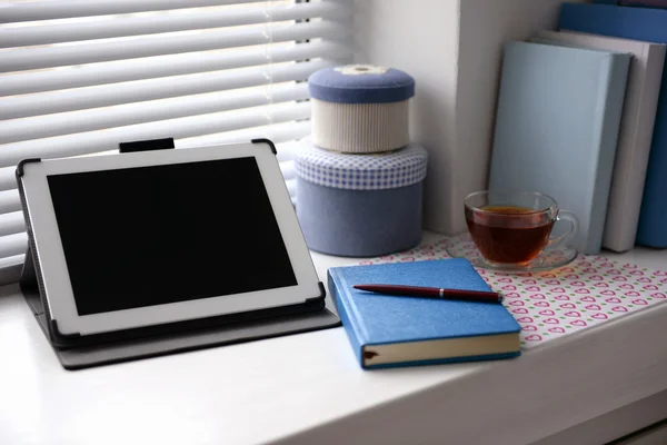 Tablet PC, notebook och kopp te på fönsterbrädan. Arbetande plats begreppen — Stockfoto