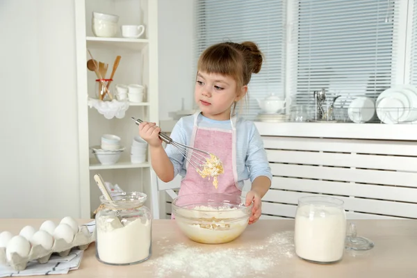 Liten flicka förbereda cookies i köket hemma — Stockfoto