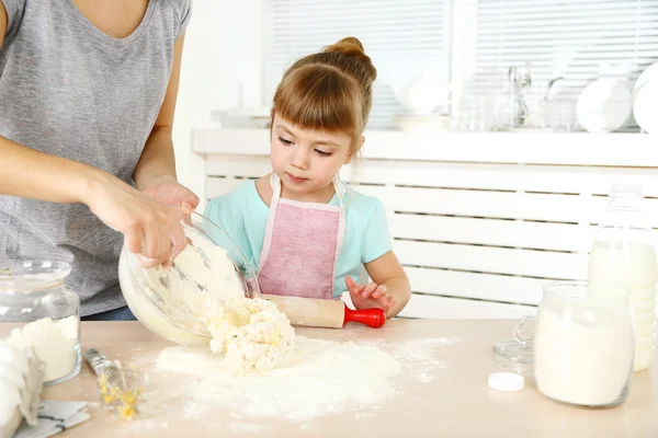 Kleines Mädchen bereitet mit Mutter zu Hause Kekse in Küche zu — Stockfoto