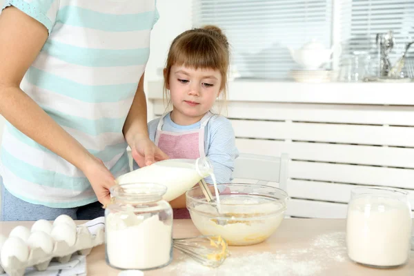 Kis lány készül a cookie-k, anya otthon a konyhában — Stock Fotó