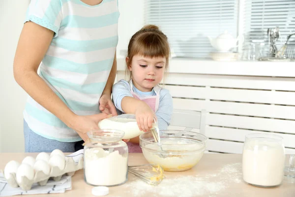 Mała dziewczynka przygotowanie ciasteczek z mama w kuchni w domu — Zdjęcie stockowe