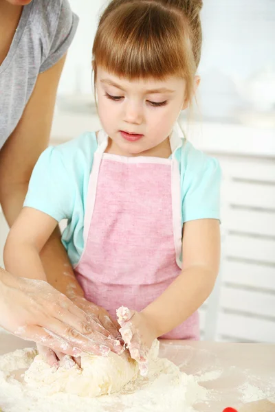 Kleines Mädchen bereitet mit Mutter zu Hause Kekse in Küche zu — Stockfoto