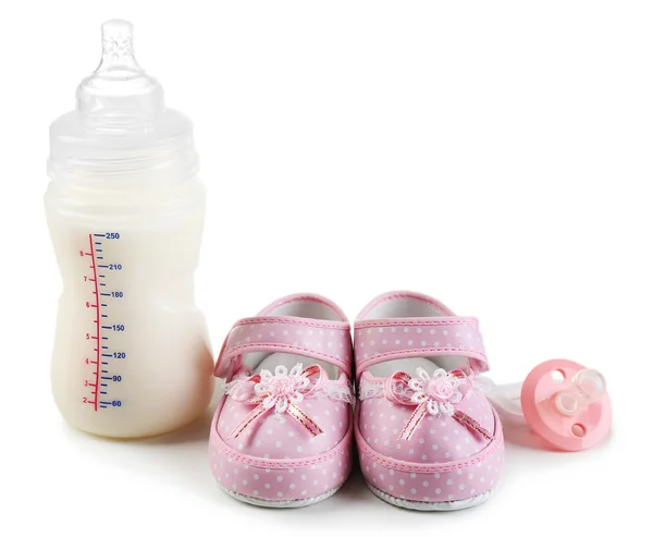 Baby shoes with nipple and bottle of milk isolated on white — Stock Photo, Image