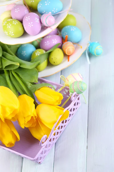 Påskägg på vas och tulpaner på bordet närbild — Stockfoto