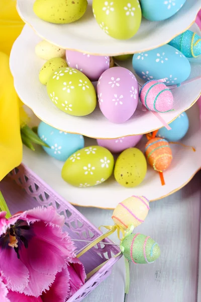 Huevos de Pascua en jarrón y tulipanes en mesa de primer plano — Foto de Stock
