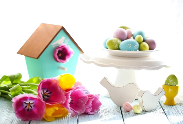 Dekorasi Paskah, telur dan tulip di atas meja dengan latar belakang cerah — Stok Foto