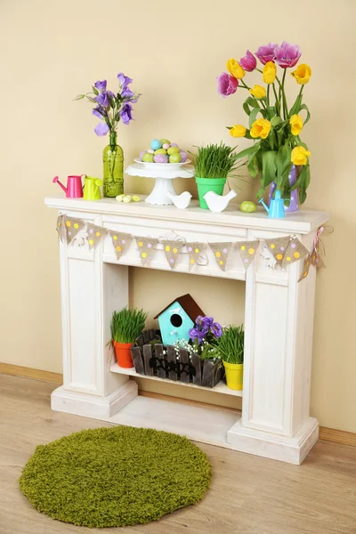 Fireplace with beautiful spring decorations in room — Stock Photo, Image