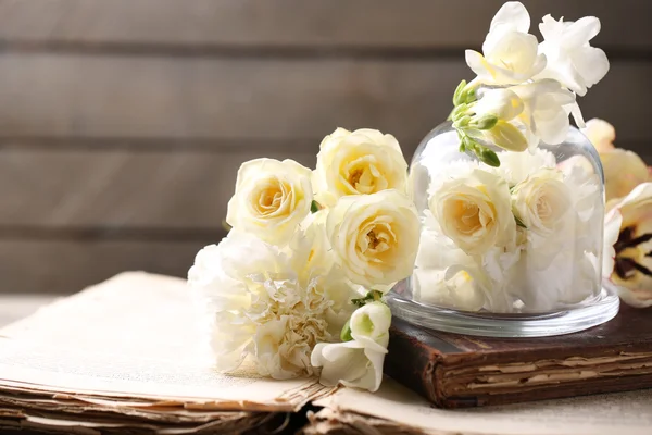 Hermosa composición con flores y libros antiguos sobre fondo de madera gris — Foto de Stock