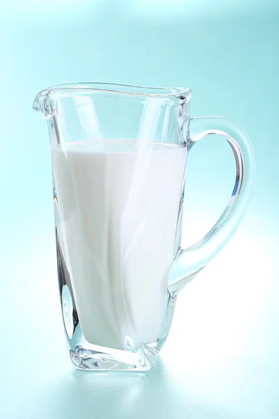 Džbán mléka na modrém pozadí — Stock fotografie