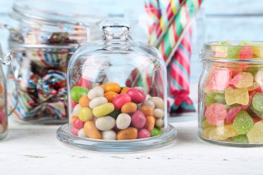 Cam Kavanoz renk ahşap arka plan üzerinde çok renkli şekerler