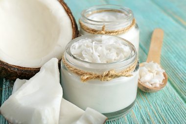 Züccaciye Mağazaları ve tahta kaşık renk ahşap masa arka plan üzerinde taze hindistan cevizi yağı