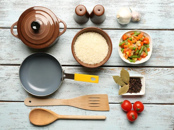 Продукты питания и кухонная утварь для приготовления пищи на деревянном фоне — стоковое фото
