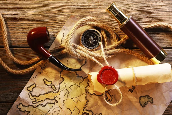 Marine still life spyglass, rope, pipe and world map on wooden background — Stock Photo, Image