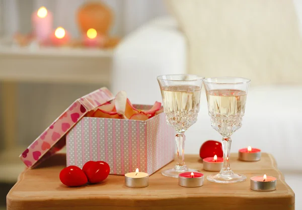 Champagne glasses, gift box and rose petals for celebrating Valentines Day — Stock Photo, Image