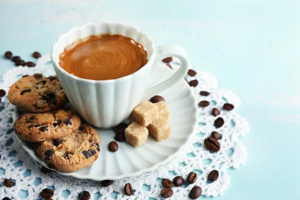 Tazza di caffè e gustoso biscotto su sfondo di legno a colori — Foto Stock