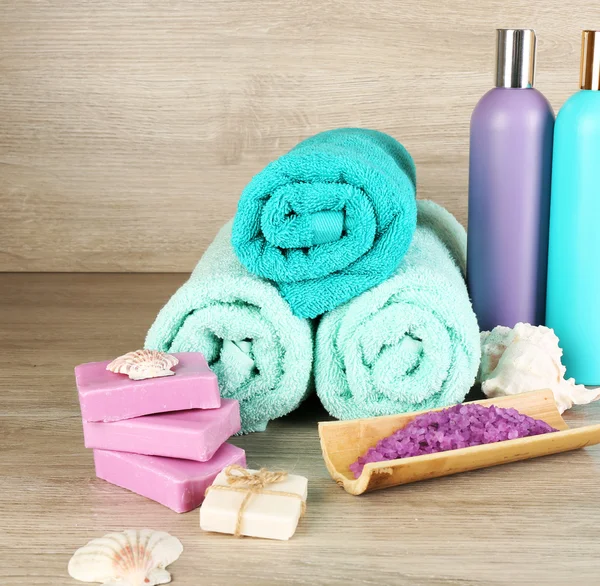 Spa samenstelling met handdoeken en zeezout op houten achtergrond — Stockfoto