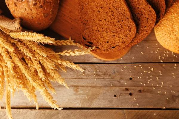 Verschillende brood met oren op houten achtergrond — Stockfoto