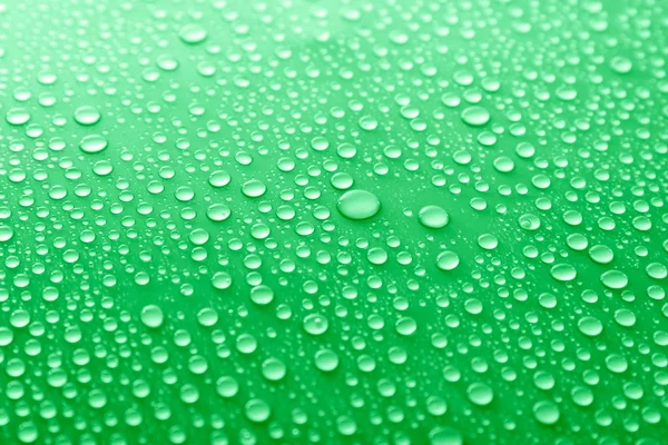 Water drops on glass on green background — Stock Photo, Image