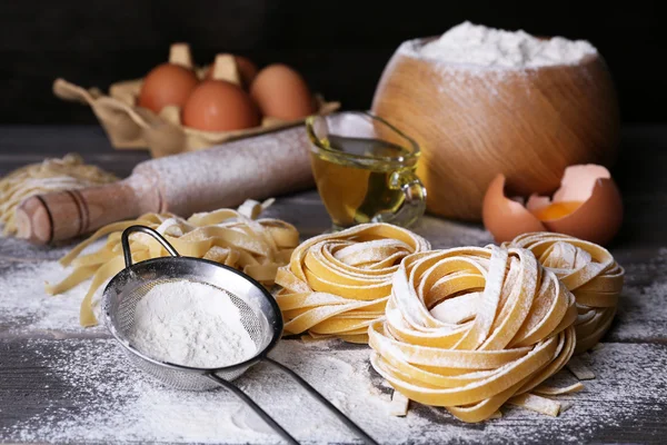 Pasta cruda fatta in casa e ingredienti per pasta su fondo di legno — Foto Stock