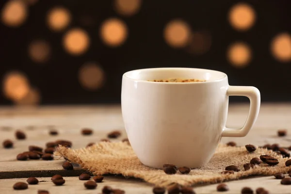 Taza de café en la mesa sobre fondo marrón —  Fotos de Stock