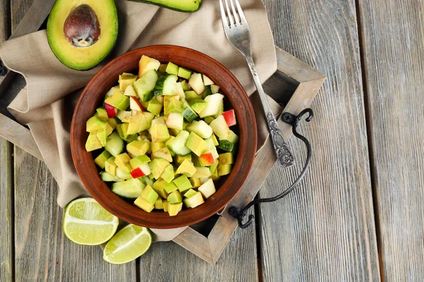 Salad with apple and avocado in bowl on tray on table close up — Stock Photo, Image