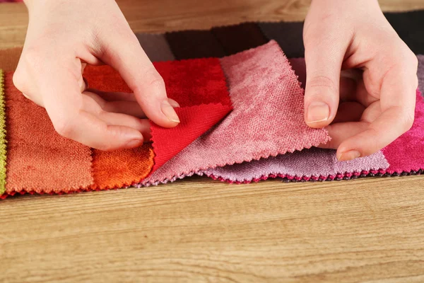 Femme choisit des morceaux de tissu coloré sur la table gros plan — Photo