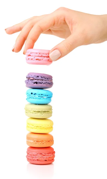 Macaroons coloridos saborosos e mão feminina isolada em branco — Fotografia de Stock