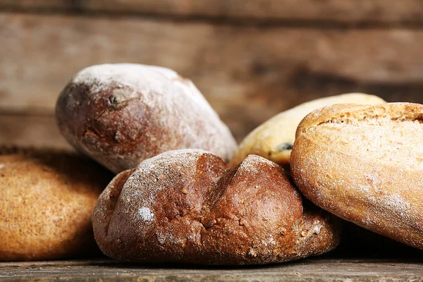 Anderes frisches Brot auf altem Holztisch — Stockfoto