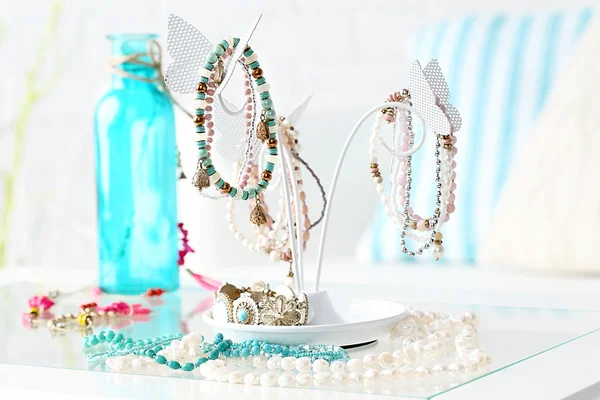 Decoratieve standaard met sieraden en bijouterie op tafel in de kamer — Stockfoto