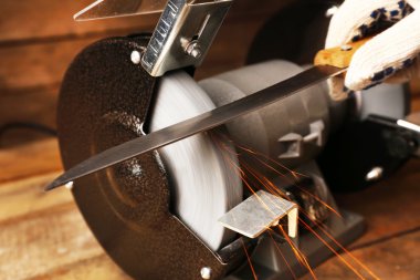 Bıçak Bileyici ve ahşap masa, closeup üzerinde bıçak el