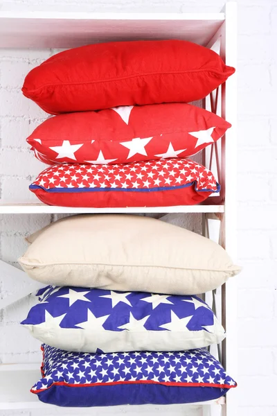 Decorative pillows on shelf on wall background — Stock Photo, Image