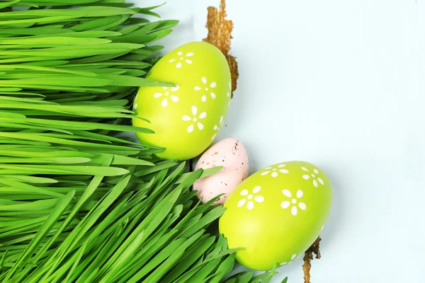 Ovos de Páscoa e grama no fundo de madeira — Fotografia de Stock