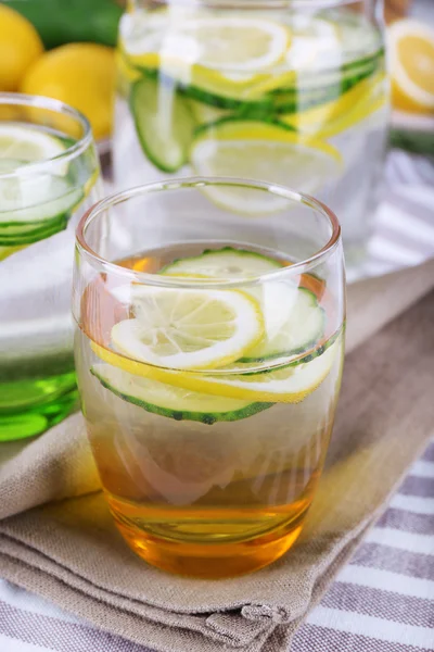 Fresh water with lemon and cucumber in glassware on napkins, closeup — Stock Photo, Image