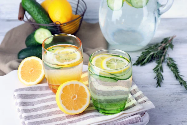 Fresh water with lemon and cucumber in glassware on wooden table, closeup — Stock Photo, Image