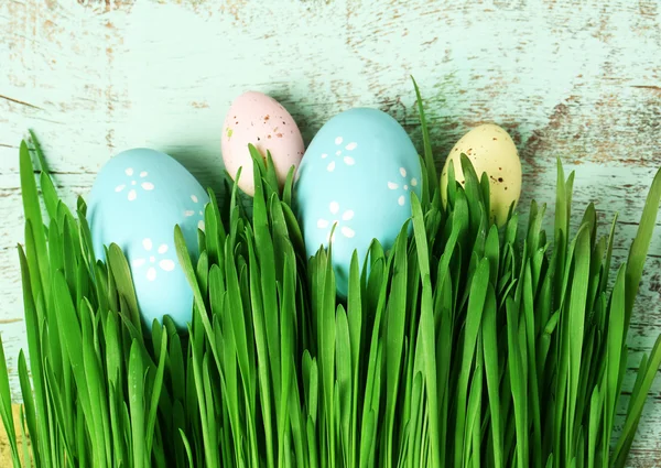 Uova di Pasqua ed erba su sfondo di legno — Foto Stock