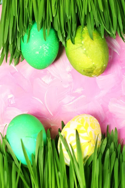 Paskalya yumurtaları ve ahşap arka plan üzerinde çim — Stok fotoğraf