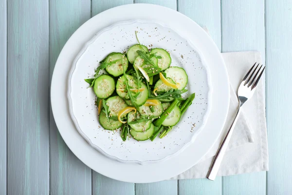 Insalata verde con cetriolo, rucola e scorza di limone sul tavolo di legno, vista dall'alto — Foto Stock