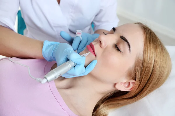 Cosmetologo applicando trucco permanente sulle labbra — Foto Stock