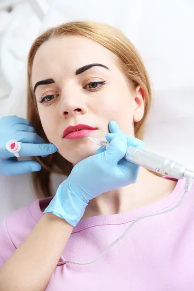 Cosmetologist aplicando a maquilagem permanente em lábios — Fotografia de Stock