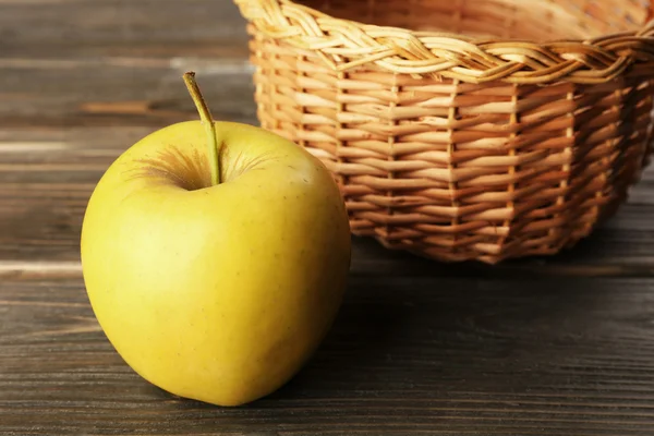 Apple z wiklinowym koszu na drewniane tła — Zdjęcie stockowe