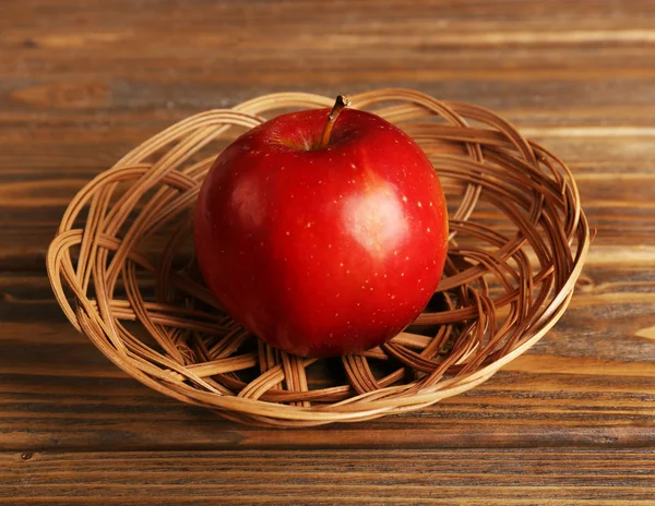 Pomme dans un panier en osier sur fond en bois — Photo